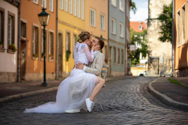 hochzeitspaar mit Stuhl auf der Strasse